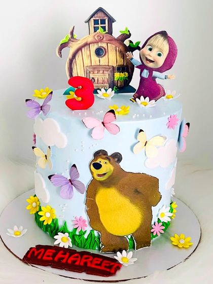 A sweet Masha and the Bear cake for Mehareef's 3rd birthday. This design uses edible prints set against a whimsical forest scene with flowers and butterflies.