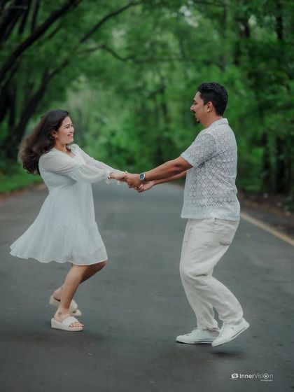 A playful and spontaneous dance in the middle of a green, tree-lined road. This shot is full of movement, joy, and the carefree spirit of love.