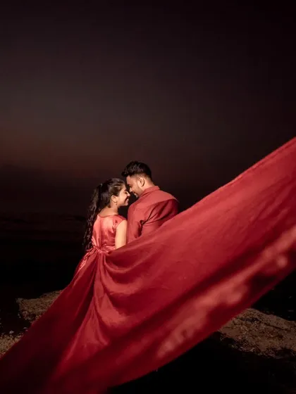A dramatic low-light shot where the red trail fills the frame. This artistic approach shows how the gown can be used to create moody and impactful pre-wedding photography.