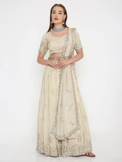 Quiet luxury at its finest. This ivory lehenga, detailed with delicate cut-danas, is a testament to understated elegance. It's a versatile piece that flatters with grace.