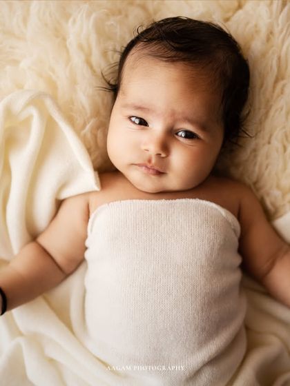 A simple, beautiful portrait of the baby from the same session, lying on a soft blanket.