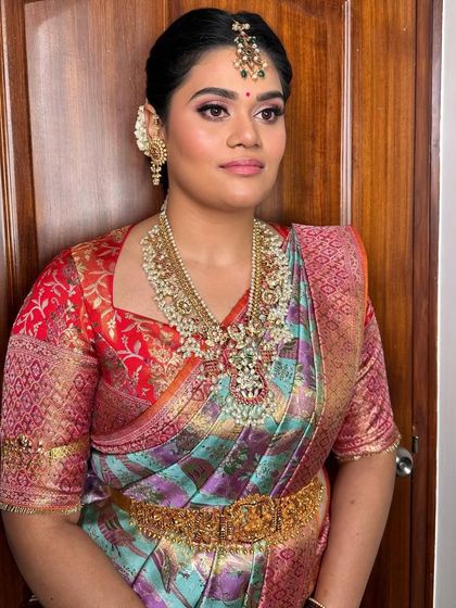 The full look, showing how the makeup complements her colorful saree and traditional gold jewelry for this important pre-wedding ceremony.