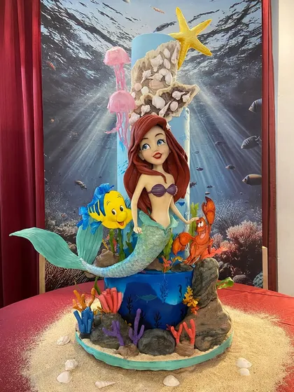 Bringing the underwater world of 'The Little Mermaid' to life was such a joy! This display cake, created for the India Bake Show, features hand-sculpted figures of Ariel, Flounder, and Sebastian amidst a vibrant coral reef. It’s a perfect example of how I can turn a beloved story into an edible masterpiece.