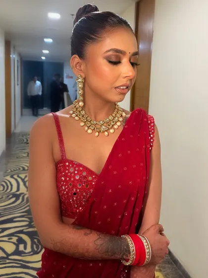 A classic look that never goes out of style. A red saree paired with bold smokey eyes and a sleek high bun for a reception or cocktail party.