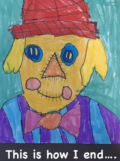 The final scarecrow, full of personality and vibrant color. The student has added patterns and details to make the character uniquely their own.