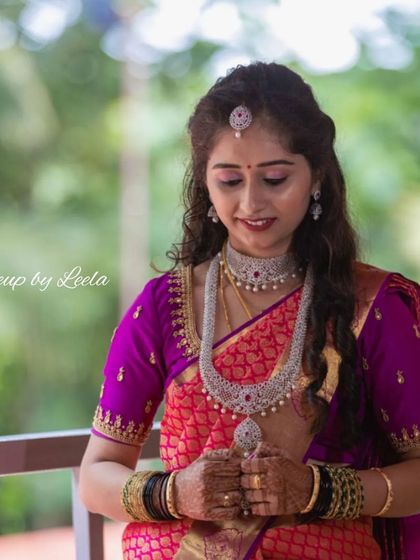 A candid shot of a bride at her reception. Her makeup is soft and luminous, paired with diamond jewelry and loose curls for a modern and sophisticated style.