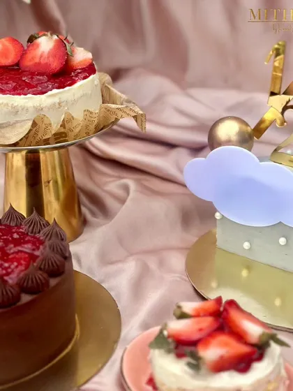 A beautiful spread of my fresh fruit cakes. This photo features mini strawberry cakes and a larger chocolate and strawberry creation, alongside a whimsical half-birthday cake, all ready for a celebration.