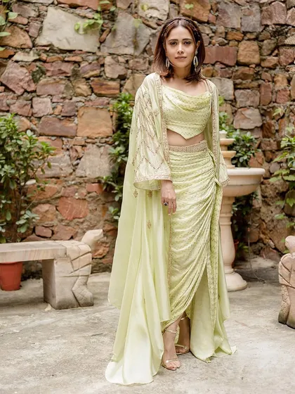 This lime green draped outfit by Punit Balanani on Nushrratt Bharuccha is perfect for a destination wedding. The cowl top and draped skirt create a chic, resort-style ethnic look.
