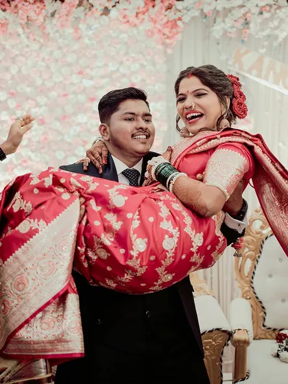A moment of pure, unscripted joy. The groom lifts his bride, and her laughter fills the room. We live for capturing these candid reception memories.