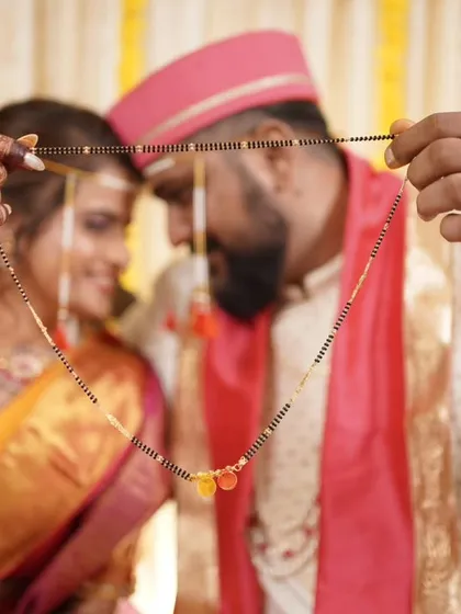 A close-up of the 'mangalsutra' ceremony, focusing on the sacred thread that unites the couple.