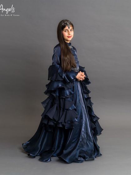 A sophisticated navy blue gown with long sleeves and a full, ruffled skirt for a dramatic and elegant look.