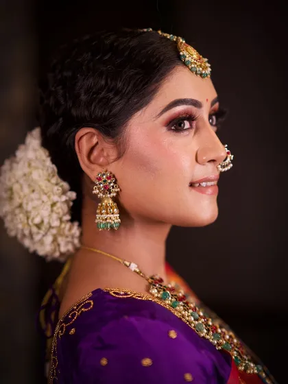 A side profile close-up, highlighting the clean makeup and classic hairstyle.