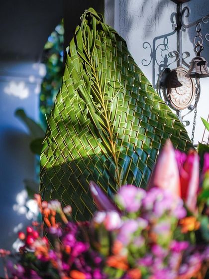 A detail of a woven coconut leaf, showcasing the beautiful craftsmanship and natural texture that we incorporate into our traditional decor.