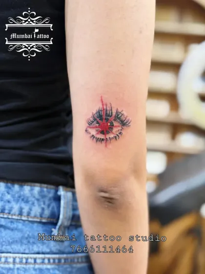 A striking abstract eye tattoo with red accents. This piece blends fine line work with a pop of color to create a unique and artistic design that draws you in.