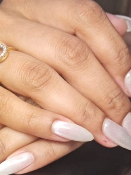 A close-up of the elegant pearly white stiletto nails.