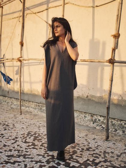 A full-length standing portrait, using the simple, rustic elements of the rooftop as a backdrop.