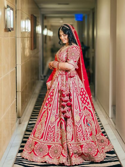 The complete look. Shikha's red lehenga, soft makeup, and elegant hairstyle come together to create a timeless and beautiful bridal aesthetic.