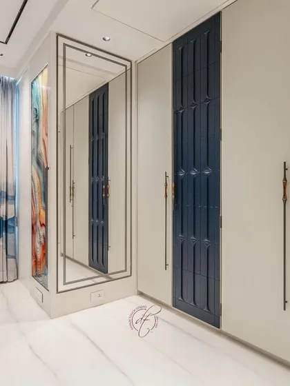 A view of the wardrobe and the full-length mirror, showing how we use reflective surfaces to enhance the sense of space. The clean lines and minimalist hardware contribute to the room's modern aesthetic.
