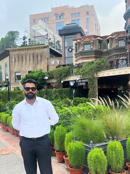 A moment captured in front of a stylish building with lush greenery. My principle is simple: whatever happens, I take responsibility.