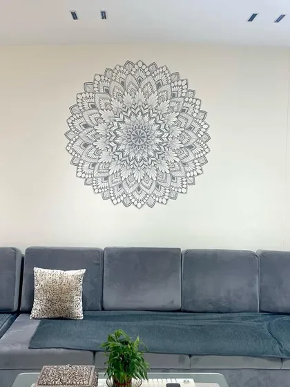 Here is how a custom mandala mural can become the soul of a living room. This piece was designed to bring a sense of calm and balance, perfectly complementing the modern grey sofa and minimalist decor.