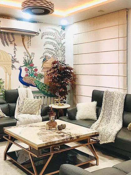 For this living room, we brought nature indoors. A beautiful, hand-painted style wallpaper featuring peacocks and foliage serves as the backdrop, complemented by neutral leather sofas and a majestic horse painting.