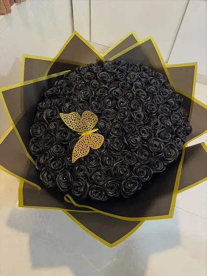 For a love that's bold and timeless, I crafted this bouquet of 100 sparkling black satin roses. These forever flowers make a dramatic statement and last as a keepsake, complete with a delicate golden butterfly accent.