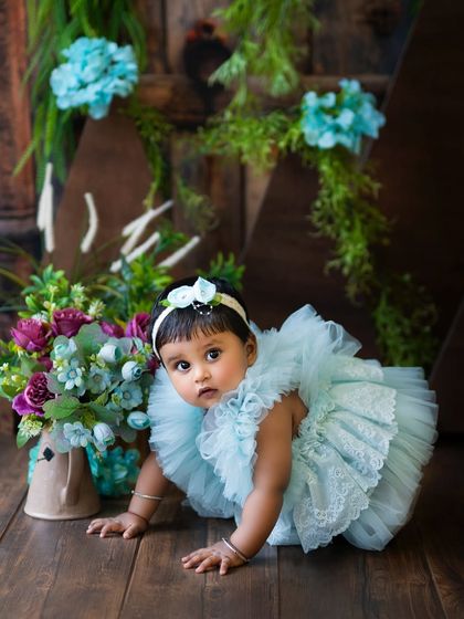 Capturing the crawling milestone! This little one is on the move in a beautiful blue dress, showing off her new skill.
