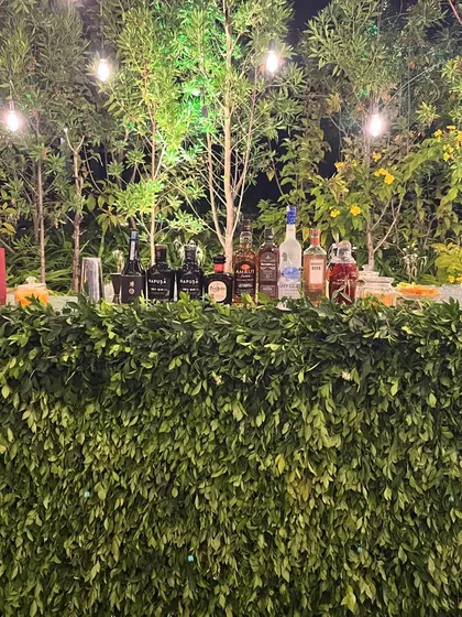For outdoor events, I can create a rustic bar that blends in with the natural surroundings. This setup, covered in lush greenery and lit with string lights, was perfect for an evening garden party.