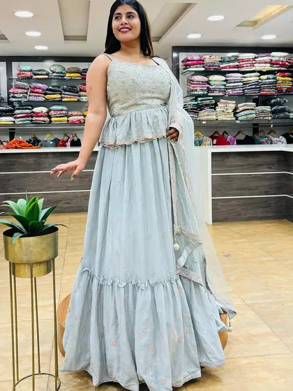 A beautiful grey sharara-style lehenga for the third day of Navratri. The peplum top and tiered skirt are both comfortable and stylish for a night of celebration.