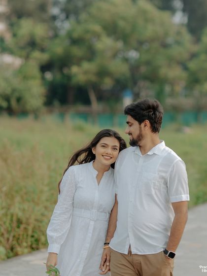 A gentle moment of rest and connection. The bride leans her head on the groom's shoulder during their pre-wedding walk, a simple gesture of love and trust.