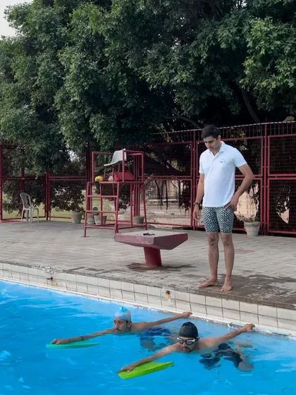 Our certified coaches provide hands on instruction and constant observation. Here, a coach guides swimmers through kickboard drills to build lower body strength and improve kicking technique.