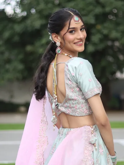 A back profile showcasing the stylish blouse and ponytail hairstyle, perfect for an engagement.