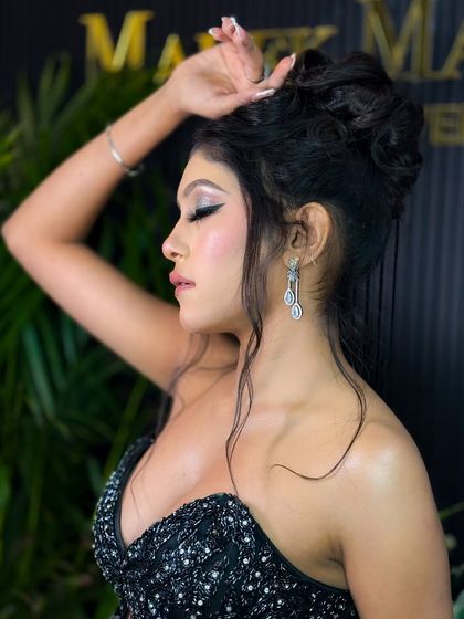 A side profile of the glamorous party look, highlighting the beautiful hairstyle and the glowing highlighter on her cheekbones.