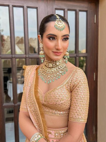 A stunning bridesmaid look featuring a sleek, clean bun that allows the statement jewelry and outfit to shine.