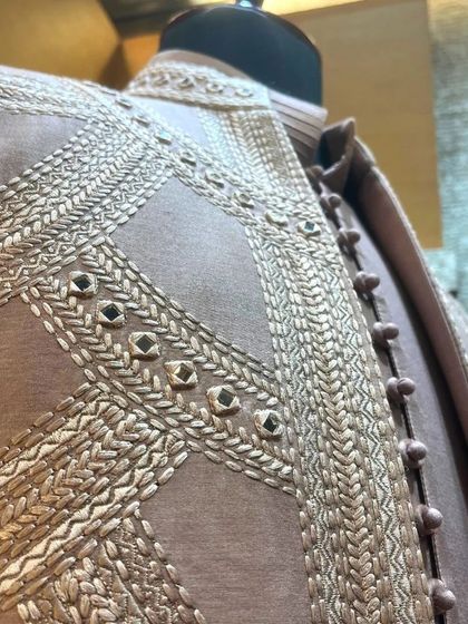 A close-up view of the fine craftsmanship, showing the interplay of threadwork and mirror accents that define our bespoke sherwanis.