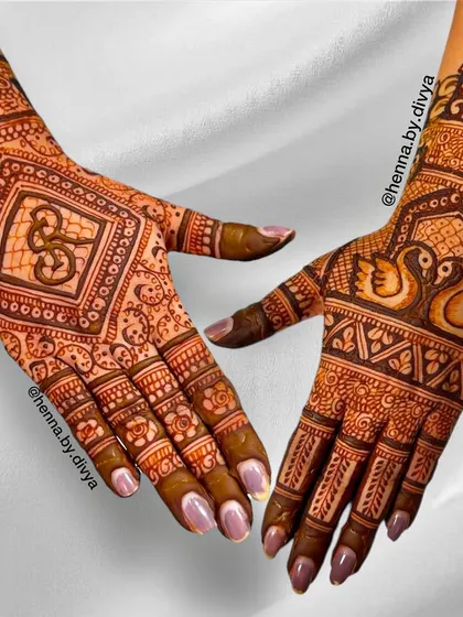 This intricate back-hand design was personalized for the bride. It features a swan couple (a symbol of love) on one hand and the groom's initial on the other, surrounded by detailed patterns.