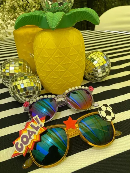 A couple of finished sunglasses designs, ready for a sunny day. One has a sporty football theme, while the other is adorned with elegant pearls and roses.