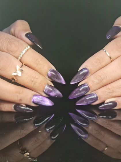 Another look at the captivating purple cat-eye stiletto nails, highlighting the deep purple and silver shimmer.