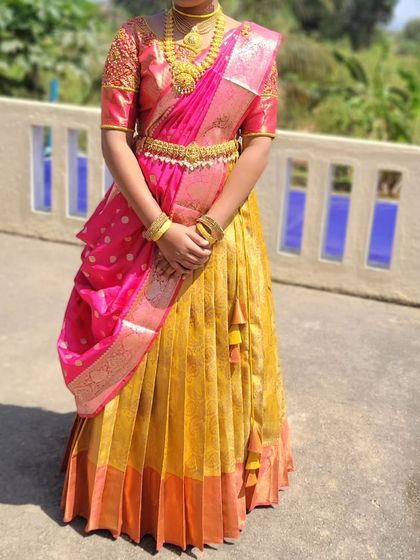 A half-saree draping for a young client. The silk lehenga and voni are styled to create a traditional yet youthful look for her ceremony.