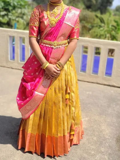 A half-saree draping for a young client. The silk lehenga and voni are styled to create a traditional yet youthful look for her ceremony.