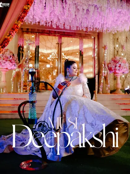 A regal portrait of the bride Deepakshi, seated gracefully in her elaborate gown next to a modern hookah, blending tradition with contemporary style.
