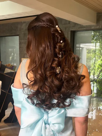 This is a fairytale-inspired half-up style. I created a soft, braided look and decorated it with delicate butterfly and floral clips. The voluminous curls add to the romantic and whimsical feel of the hairstyle.