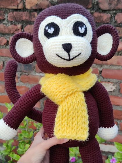 A cozy monkey plushie with a bright yellow scarf, perfect for winter cuddles.