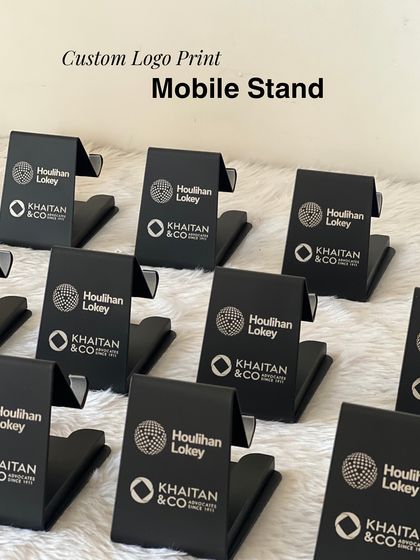 Sleek and practical custom mobile stands with logos for Houlihan Lokey and Khaitan & Co. This is a perfect example of a branded giveaway that attendees will use daily.