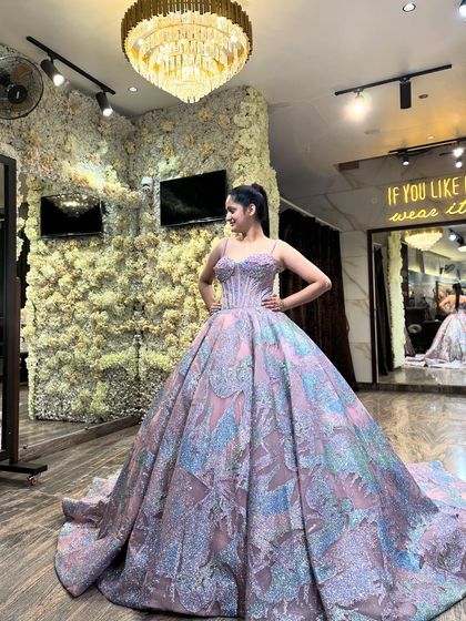 A client trying on the multi-colored pastel glitter ball gown in my studio. The lighting catches the different hues in the fabric, from pink to blue, creating a magical, iridescent effect.