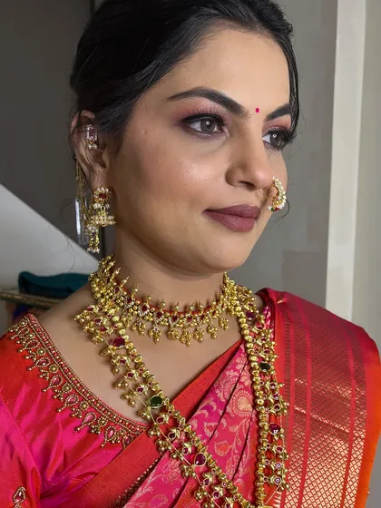 A glamorous look for a Munj ceremony. The makeup features a smoky eye and a bold lip, perfect for the celebratory occasion.