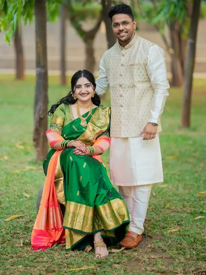 A classic seated portrait of Jagruti and Shubham in a park. This pose is timeless and showcases their elegant traditional outfits perfectly.