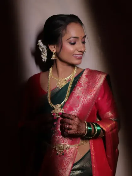 An artistic, moody shot of a Sakarpuda bride. The lighting highlights her glowing skin and the beautiful details of her traditional silk saree.
