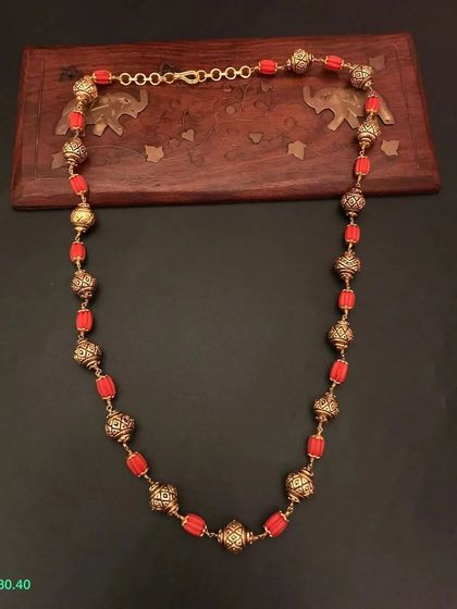 A beautiful beaded necklace made with red beads and ornate golden beads. This piece is crafted from 92.5 silver with gold plating for a premium finish.