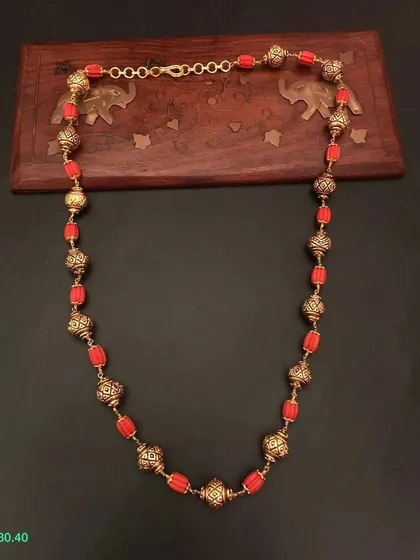 A beautiful beaded necklace made with red beads and ornate golden beads. This piece is crafted from 92.5 silver with gold plating for a premium finish.